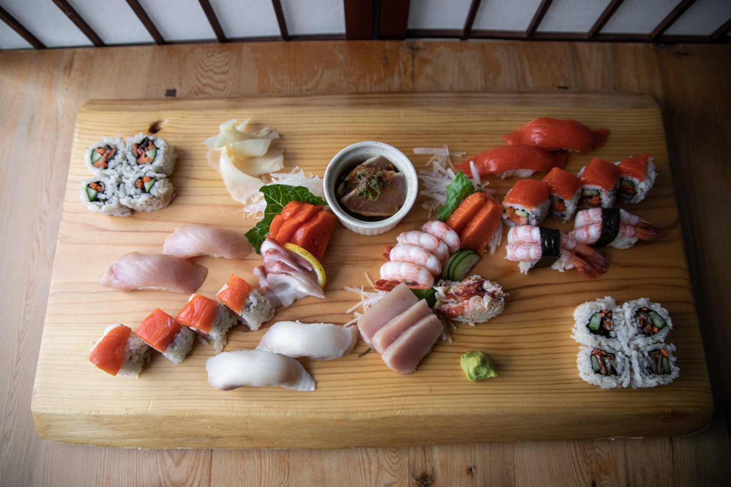A hot seafood dish being served at a cedar table inside Fukasaku